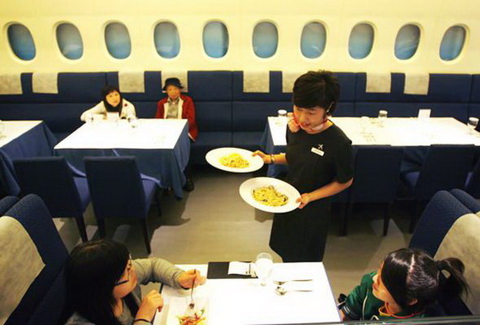 A waitress dressed as a flight attendant serves customers inside the A380 In-flight Kitchen, a restaurant named after the giant Airbus airliner, in Taipei